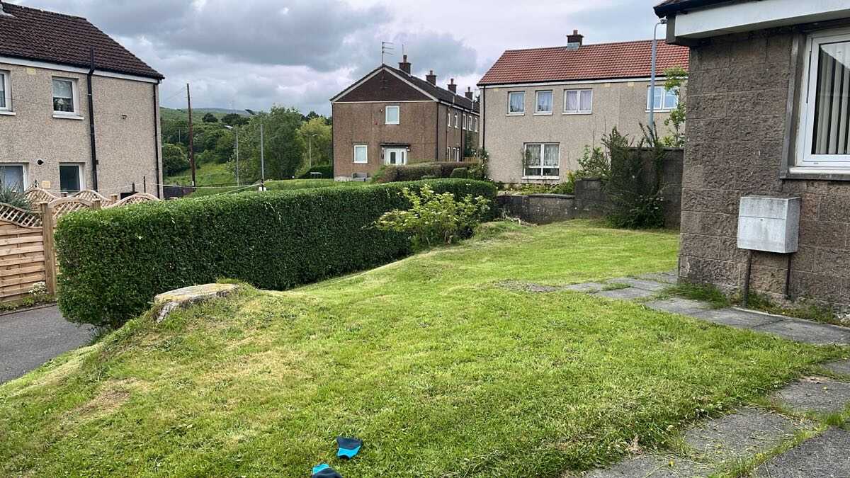 Tidy maintained garden with cut grass and trimmed hedge